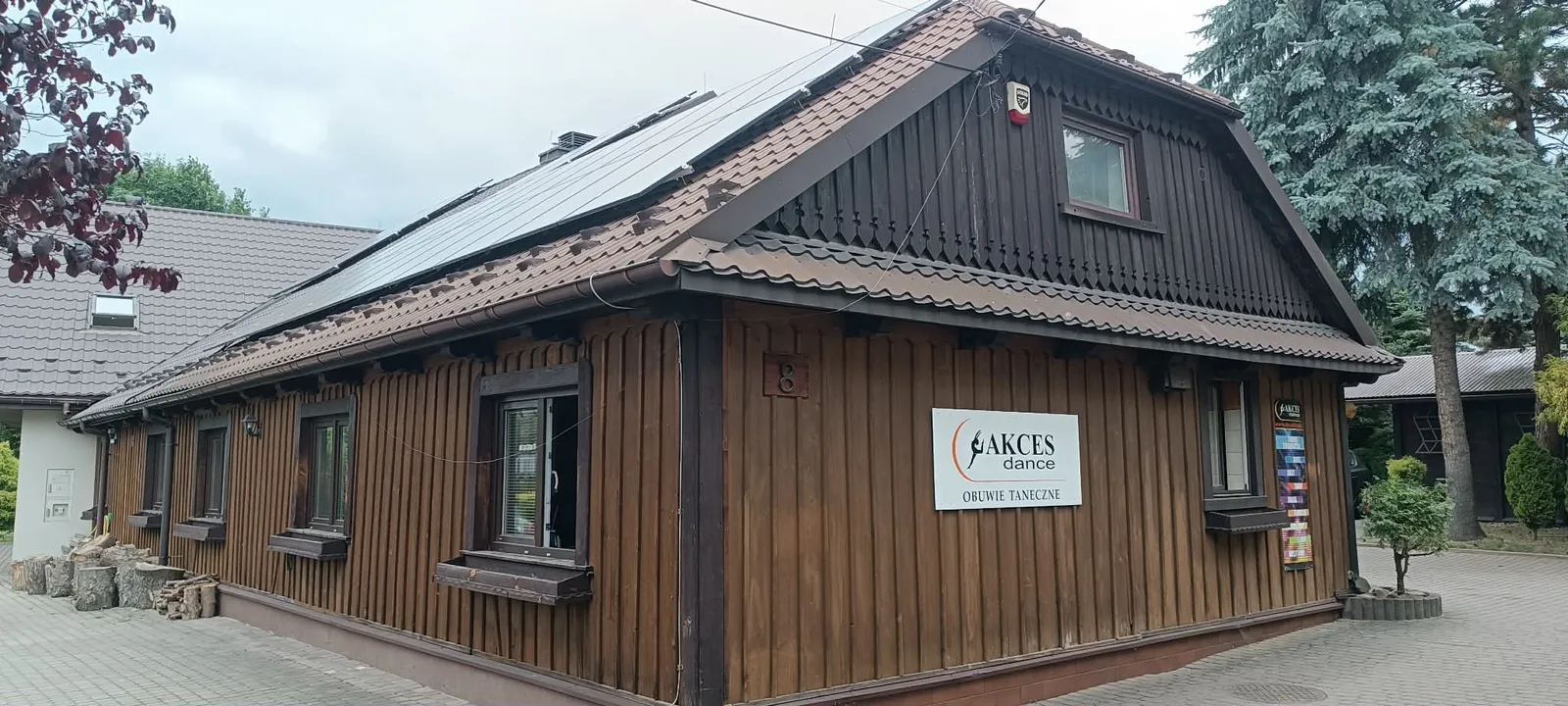 Drewniany budynek zakładu widziany z boku.